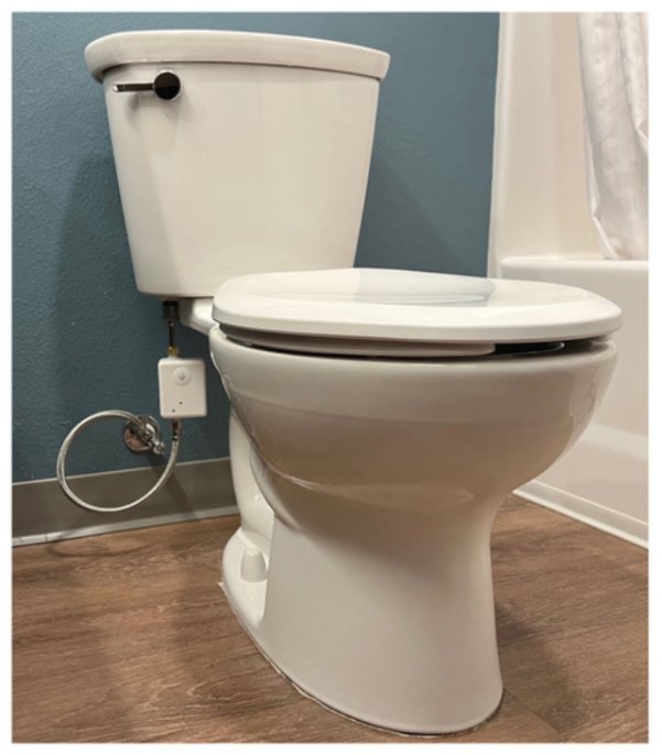 The CONSERV+ Water Lock installed in-line on the supply line behind a guest-room commode